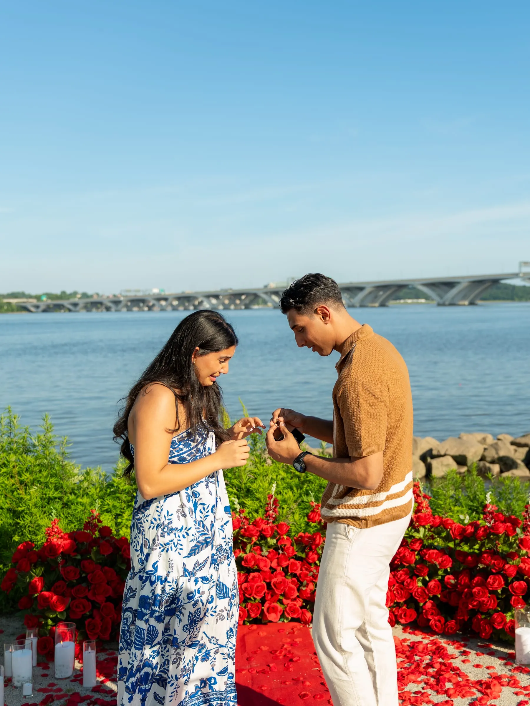 Thomas placing the ring on Verina's finger beside the river