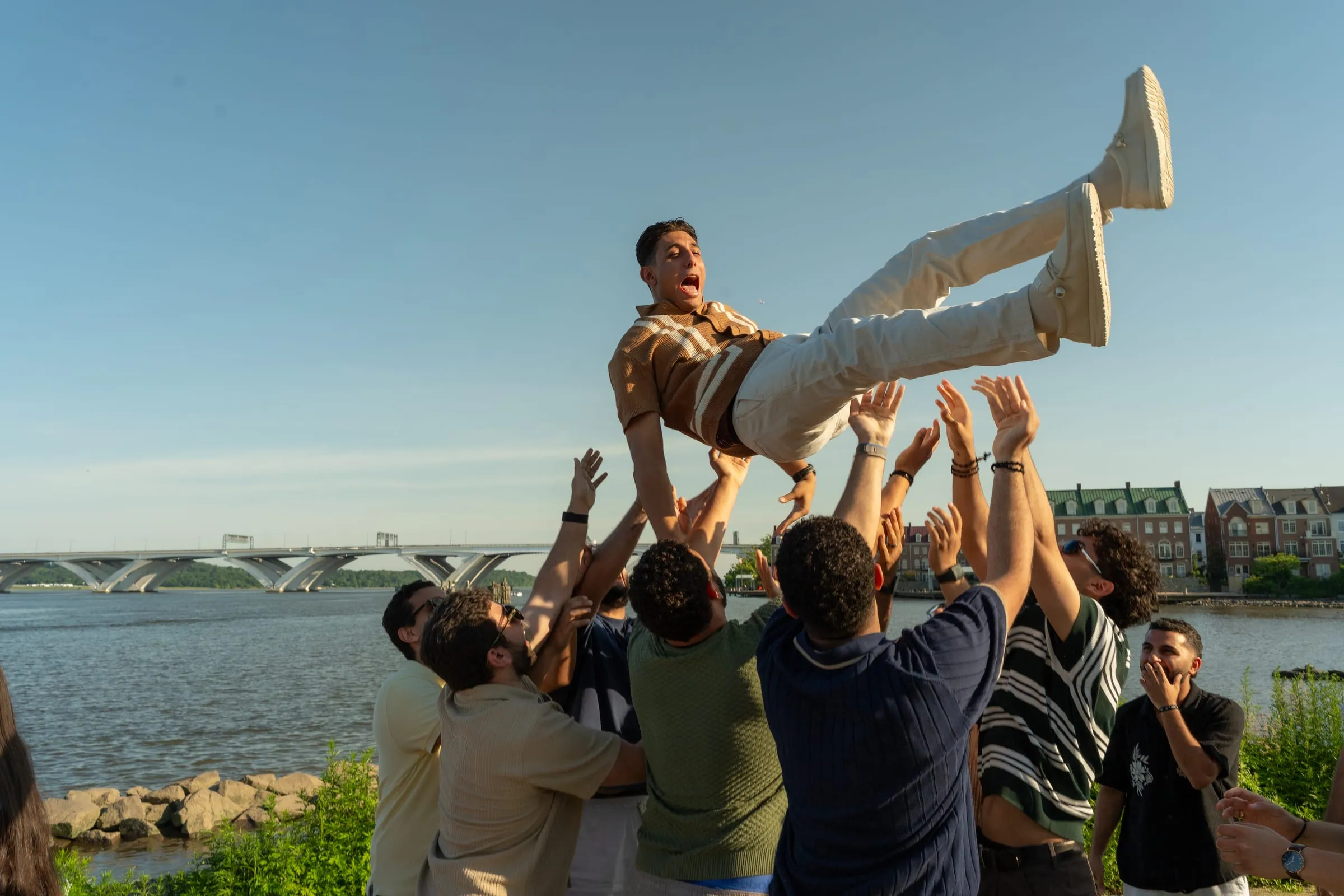 Thomas's friends tossing him into the air to celebrate the engagement